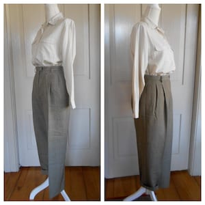 May include: A pair of high-waisted, pleated pants with a plaid pattern in shades of brown and white. The pants are cuffed at the bottom and are being displayed on a mannequin.