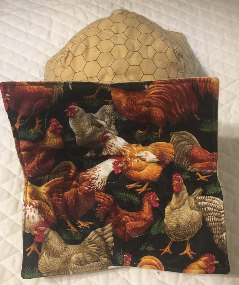May include: A quilted fabric item featuring a black background with a repeating pattern of colorful chickens in various poses. The chickens are in shades of red, brown, white, and tan. The item is paired with a tan, hexagonal patterned item.