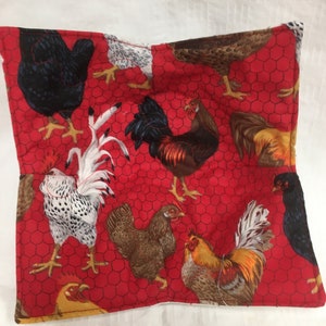 May include: A square, quilted fabric bowl cozy featuring a vibrant red background with a chicken wire pattern. The fabric is adorned with various illustrations of chickens and roosters in shades of brown, black, white, and yellow.