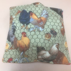 May include: Square, quilted pot holder featuring a repeating pattern of chickens and roosters in various colors on a light green background. The design includes a chicken wire pattern. The pot holder is likely made of fabric and has a stitched edge.