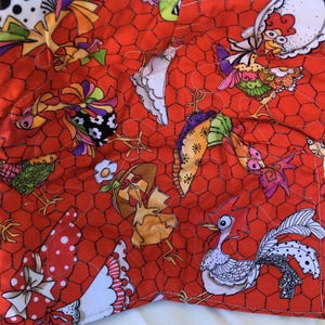 May include: A quilted fabric with a vibrant red chicken wire pattern. The fabric is adorned with whimsical, colorful chicken illustrations. The chickens are depicted in various poses and outfits, adding a playful touch to the design. The fabric is likely used for crafting or home decor.