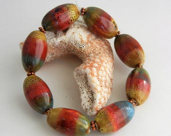 Colorful ceramic stretch fashion bracelet, copper spacers, blue, gold, red, olive, Fall colors, African. painted beads