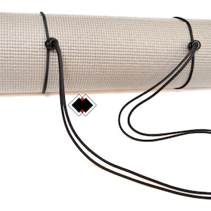 May include: A rolled-up yoga mat with a black elastic strap for carrying.