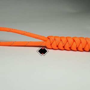 May include: Orange and grey paracord key chain with a braided knot.