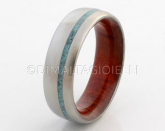 May include: A silver ring with a turquoise inlay and a red wood band.