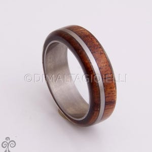 May include: A brown wooden ring with a silver inlay, set in a silver band.