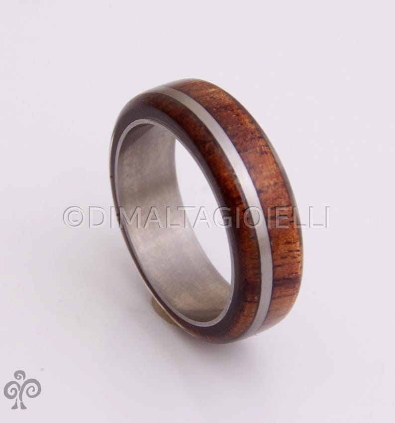 May include: A brown wooden ring with a silver inlay, set in a silver band.