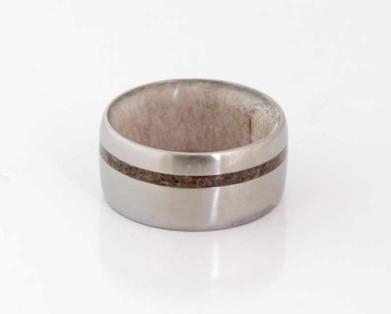 May include: A silver titanium ring with a brown wood inlay band.