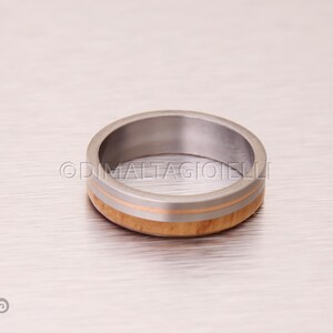 May include: A silver ring with a thin band of wood and a thin band of gold.