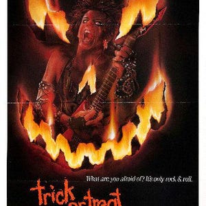 May include: A movie poster for the horror film "Trick or Treat" featuring a person with long black hair playing a guitar in front of a fiery jack-o'-lantern. The text on the poster reads "What are you afraid of? It's only rock & roll. Trick or Treat."