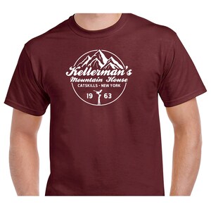 Puede incluir: Una camiseta de color granate con un gr&aacute;fico blanco de una cordillera y el texto "Kellerman's Mountain House Catskills - New York 19 63"