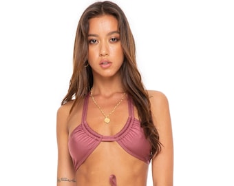 May include: A mauve-colored bikini top and bottom with a gold accent. The top has a halter style with a tie at the neck and a tie at the waist. The bottom has a high-cut leg and a tie at the waist.