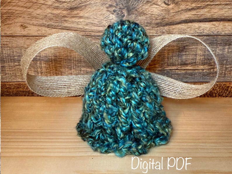 May include: A teal and gold yarn angel, handmade with a round head and flared body. It features jute ribbon wings. The words "Digital PDF" are at the bottom of the image.