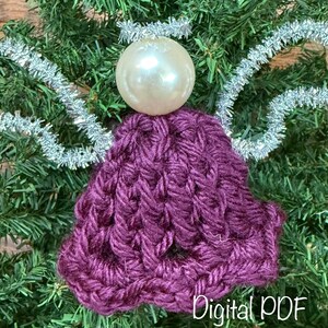 May include: A handmade Christmas angel decoration with a pearl-like head and a crocheted purple body. Silver tinsel forms the wings and halo. The words "Digital PDF" are at the bottom.