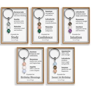 May include: Keychains with crystal beads in various colors, each with a different purpose. The keychains are displayed on cards with text such as "Study", "Confidence", "Intuition", "Birthday Blessings", and "Sweet 16 Birthday".