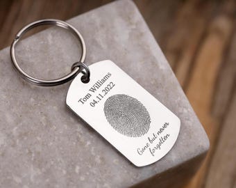 May include: Silver keychain with a fingerprint design and the text "Tom Williams 04.11.2022 Gone but never forgotten".