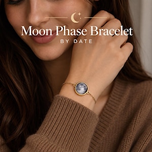 May include: A gold-toned chain bracelet featuring a circular pendant with a detailed lunar surface image. The text 'Moon Phase Bracelet BY DATE' is displayed above the jewellery piece, accompanied by a small crescent moon and star icon.