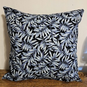 May include: A black and blue throw pillow with a leaf pattern. The pillow is made of a soft, comfortable fabric and is perfect for adding a touch of style to any room.