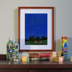 Puede incluir: Una pintura enmarcada de un cielo nocturno estrellado con una fogata y una tienda de campa&ntilde;a en primer plano. La pintura est&aacute; en un estante con libros y un frasco de canicas.