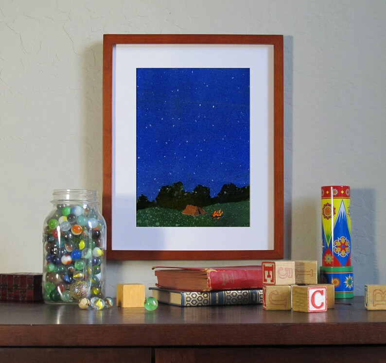 Puede incluir: Una pintura enmarcada de un cielo nocturno estrellado con una fogata y una tienda de campa&ntilde;a en primer plano. La pintura est&aacute; en un estante con libros y un frasco de canicas.