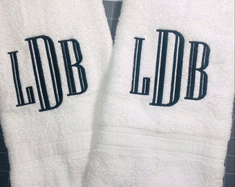 May include: Two white towels with black embroidered initials "LDB" on each.