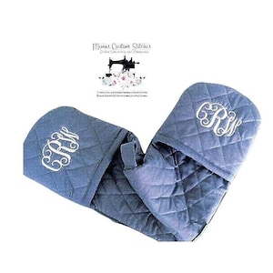 May include: A pair of blue quilted oven mitts with white embroidered initials "R.R." on each mitt.