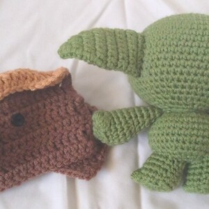 Pu&ograve; includere: Due giocattoli di peluche all'uncinetto. Uno &egrave; marrone con la faccia color beige e l'altro &egrave; verde con grandi orecchie.