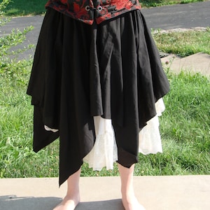 May include: A black skirt with a white lace trim and a red and black floral corset top.