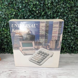 May include: A box for a Universal Keypad, featuring an image of a small laptop and a separate numeric keypad. The box has a cityscape background and the words "UNIVERSAL Keypad" in large letters.