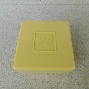 May include: A yellow plastic box with a butterfly design on the lid.