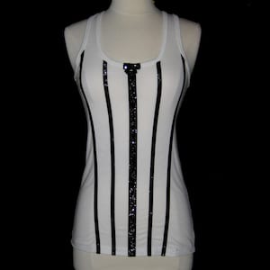 May include: White tank top with black vertical stripes and a sparkly black bow detail.