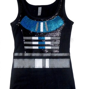 May include: Black tank top with a blue and silver sequined design. The design features a geometric pattern with stripes and a belt.