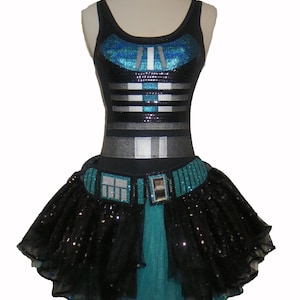 May include: A black and teal sequined dress with a black tulle skirt. The bodice features a silver and black striped design and a teal sequined panel. The skirt has a teal and black sequined belt with a silver buckle.