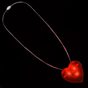 May include: A red heart-shaped LED light necklace with a clear plastic cord. The necklace is lit up and the heart is glowing.