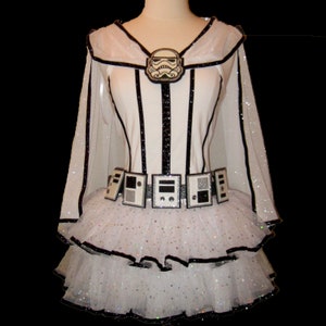 May include: White tulle tutu with black trim and a white bodice with black stripes. A silver and black Stormtrooper helmet is attached to the bodice. The tutu has a black belt with silver details.