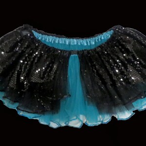 May include: A black and turquoise tulle skirt with sequins. The skirt has a ruffled hem and a satin waistband.