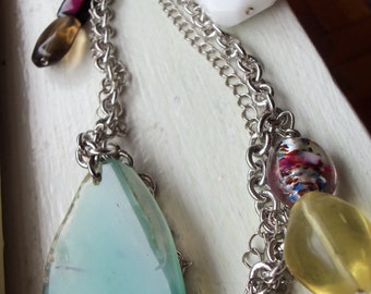 Gedrehte, doppelsträngige Silberkette mit Stein-, Glas- und Muschelperlen in weissen, gelben, grünen, lila und rosa Tönen