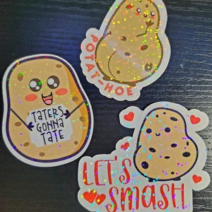 Puede incluir: Tres pegatinas holográficas con dibujos animados de patatas con purpurina. La primera pegatina dice "Potato-Hoe" y presenta una patata con rubor. La segunda pegatina dice "Taters Gonna Tate" y presenta una patata sosteniendo un cartel. La tercera pegatina dice "Let's Smash" y presenta una patata con corazones.