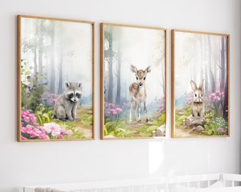 May include: Three framed watercolor paintings of woodland animals in a nursery setting. The paintings feature a raccoon, a deer fawn, and a rabbit. The paintings are set against a backdrop of a forest with pink flowers.