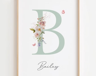 May include: A framed print featuring a large, light green letter "B" adorned with watercolor flowers and butterflies. The name "Bailey" is written in cursive below the letter. The artwork is set against a white background.