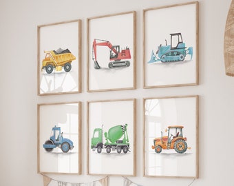 May include: A set of six framed watercolor illustrations of construction vehicles, including a dump truck, excavator, bulldozer, roller, cement mixer, and tractor. The illustrations are displayed on a white wall above a wooden shelf with storage bins.