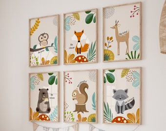May include: A collection of six framed art prints featuring woodland animals and inspirational phrases. The illustrations include an owl, fox, deer, bear, squirrel, and raccoon, with phrases like "Be kind" and "Be brave". The prints are displayed above a wooden storage unit.