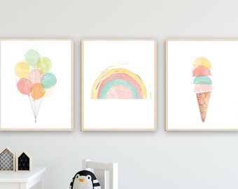 May include: Three framed watercolor illustrations on a white wall. The first illustration shows a cluster of colorful balloons. The second illustration shows a rainbow with a pink, blue, and green color scheme. The third illustration shows a pink, blue, and green ice cream cone.