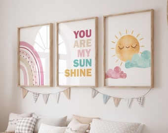 May include: A nursery room with a wooden bench and three colorful framed prints on the wall. The prints feature a rainbow, a sun, and the text "You are my sunshine".