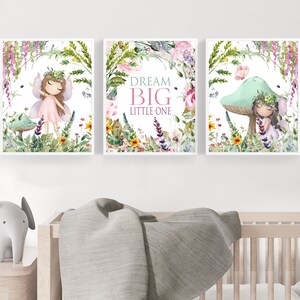 May include: Three watercolor prints featuring fairies in a whimsical garden setting. The center print features the text "Dream Big Little One".