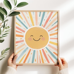 Può includere: Una stampa incorniciata di un sole sorridente con raggi colorati che irradiano verso l'esterno. Il sole è giallo con un viso felice e guance rosate. Lo sfondo è blu chiaro con strisce rosa, gialle e arancioni.