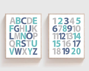 May include: Two framed prints with a white background. The print on the left features the alphabet in gray, blue, and teal. The print on the right features the numbers 1 through 20 in gray, blue, and teal.
