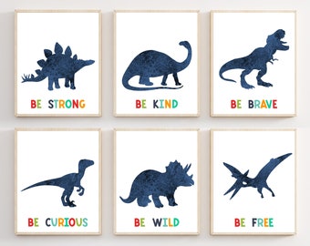 May include: Six framed art prints featuring dark blue dinosaur silhouettes on a white background. Each print has a different dinosaur and a colorful word: "BE STRONG," "BE KIND," "BE BRAVE," "BE CURIOUS," "BE WILD," and "BE FREE."