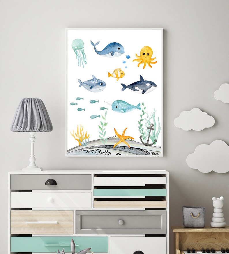 Peut inclure: Une illustration aquarelle d'une vari&eacute;t&eacute; de cr&eacute;atures marines, dont une baleine, une pieuvre, une narval, un requin, une m&eacute;duse et une &eacute;toile de mer. L'illustration est sur un fond blanc avec un motif de vague bleu et gris en bas.