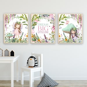 May include: Three framed prints with a whimsical fairy theme. Each print features a fairy with a pink dress and a floral crown, surrounded by flowers and greenery. The middle print has the text "Dream Big Little One".